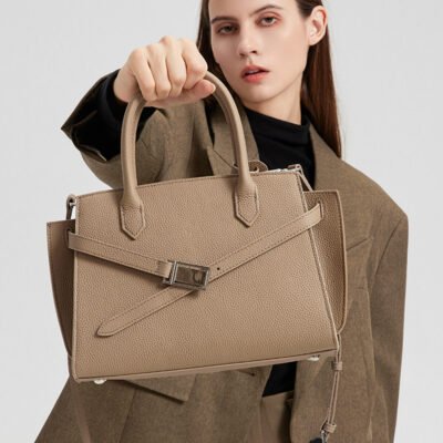 a woman wearing the Aura model of a luxury handbag from the Donna Puo brand in beige color