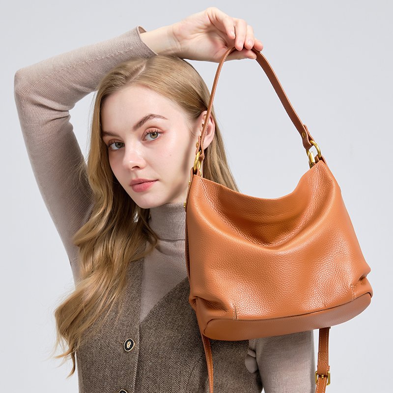 woman in studio carrying a donna puo leather bag model - Marcella in orange color